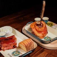 Pečená vepřová BBQ žebra s hořčicí, křenem a zelným salátem, rozpečený chléb a Pečené vepřové koleno s naklá Pečená vepřová BBQ žebra s hořčicí, křenem a zelným salátem, rozpečený chléb a Pečené vepřové koleno s naklá